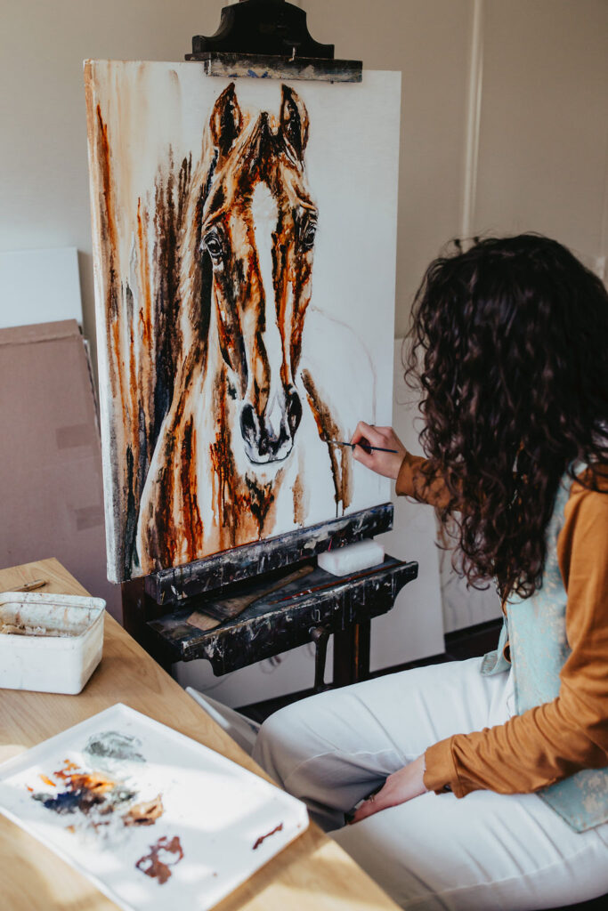 Marjo Lebbe painting a custom horse portrait on her easel
